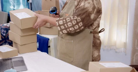 Close view shows older artisan hands scanning barcode label on parcel box, Vidéo 330591881