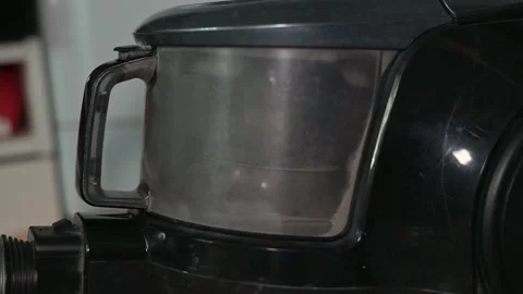 A close-up view shows the process of cleaning a vacuum cleaner container. The Stock Footage 339005111