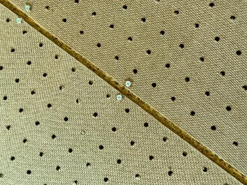 A close view shows a surface with evenly spaced holes and a visible seam. Lig Stock Photos