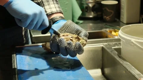 Close-up view of a shuckers hands in protective chainmail and latex gloves Stock Footage 317648420