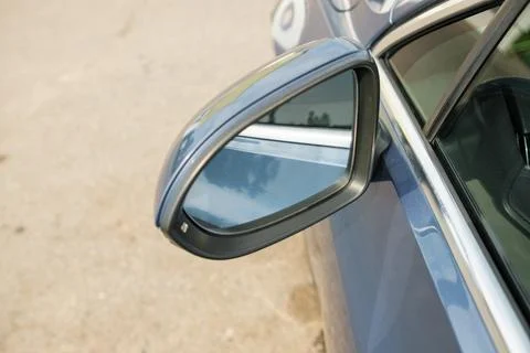 Close-up view of a side mirror on a blue car parked on a gravel surface Foto stock