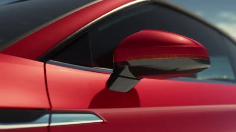Close view of the side mirror of a red sports car in sunny outdoor setting Vidéo 343549012