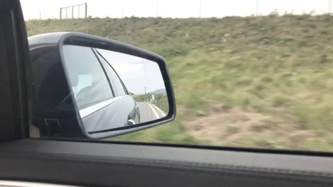 Close-up view of side mirror from vehicle on motorway. Driving a car along field Stock Footage 118249490