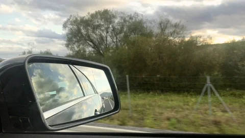 Close-up view of side mirror from vehicle on motorway. Driving a car along field Stock Footage 118249933