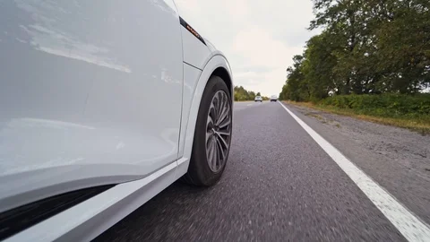 Close-up view on the side part of a car and a wheel at moving the road. Stock Footage 117251822