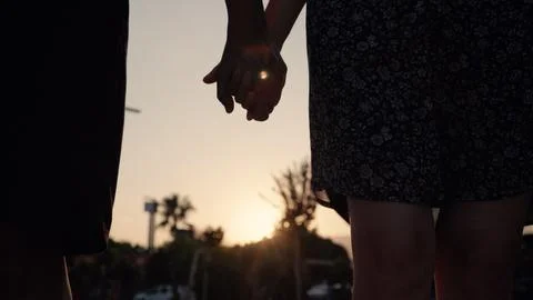 Close up view of silhouette of hands joining together with sunset on the Stock Photos