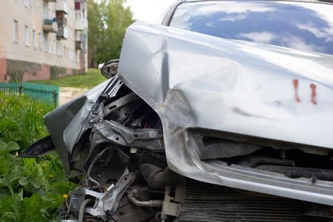 Close-up view on silver car physically damaged in road accident, close-up with Stock Photos