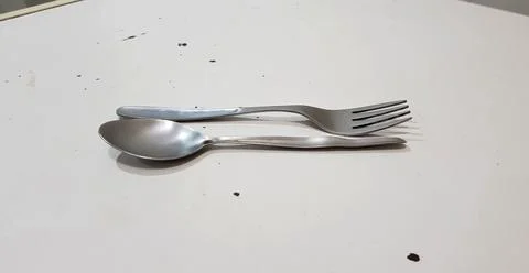 Close up view of a single silver spoon and fork in horizontal style isolated Stock Photos