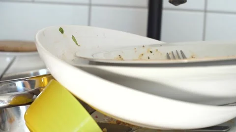 Close up view of a sink full of dirty dishes, cluttered home kitchen Stock Footage 291670678