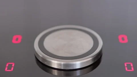 A close-up view of a sleek induction cooktop with illuminated controls ready for Stock Footage 281598358