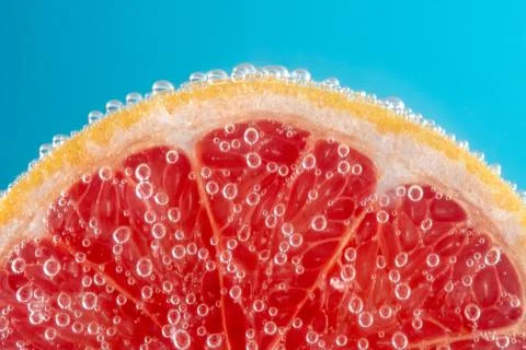 Close up view of a slice of grapefruit in soda water with bubbles. Foto stock