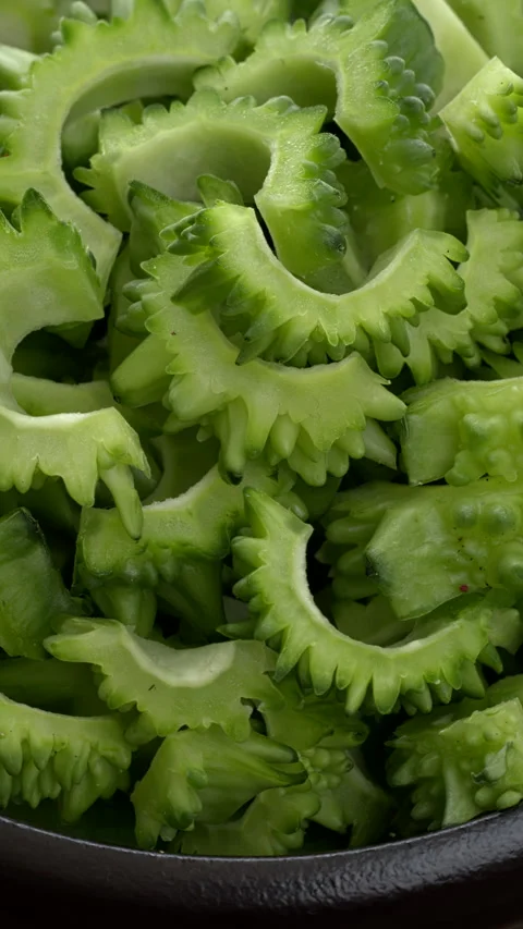 Close up view of sliced bitter gourd in bowl.  Vertical video. Stock Footage 284558509