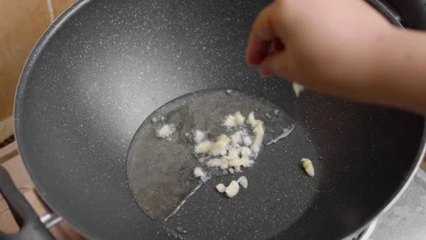 Close-up view of sliced Garlic Frying In Pan. Cooking Process. food prepara.. Stock Footage 329703936