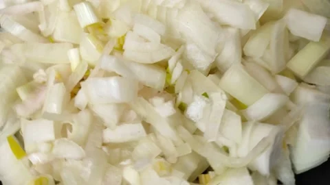 Close-up view sliced onion rotates in a black plate. Stock Footage 197486080