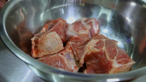 Close UP View of the Slices of Delicious Meat in a bowl and hand is slting it 库存影片 104127076