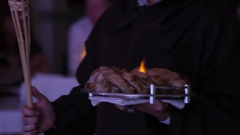 Close-up view of slices of meat with flames on the plate in waiters hand Stock Footage 107882559