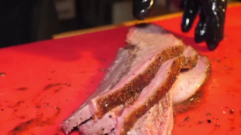 Close-Up View of Slicing Smoked Beef Brisket on a Red Cutting Board 스톡 동영상 332813702
