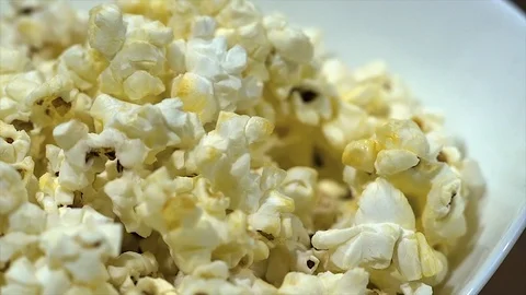 Close up view of a slowly rotating bowl with freshly baked popcorn Stock-Footage 87996787