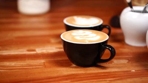 Close up view on small black minimalistic coffee cups with cappuccino and hot Stock Footage 105454244