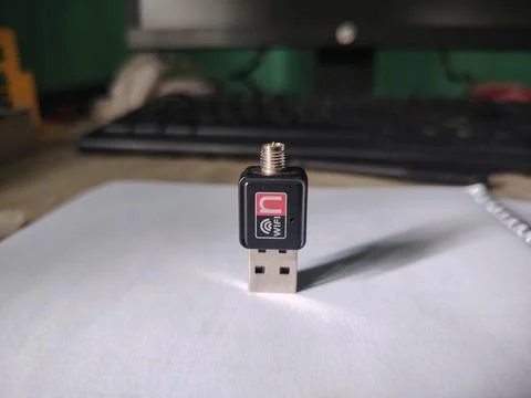 Close up view of a small black USB wireless network adapter with a red and .. 스톡 사진