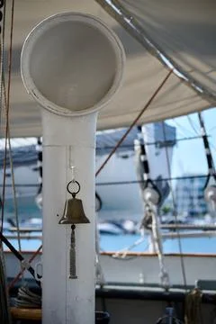 Close up view of small brass bell attached to a white deck ventilator pipe on Stock Photos