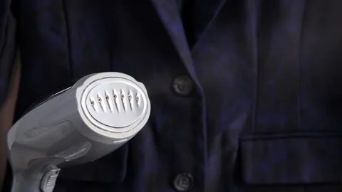 Close up view of small handheld fabric clothing steamer machine. Stock Footage 149512122