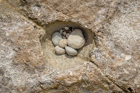 Close-up view of small pebbles gathered in a natural rock hollow on a Cyprus  Stock Photos