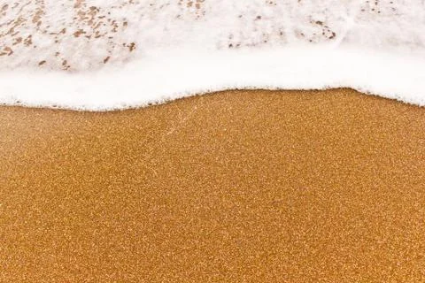 Close view of the small sea wave on the sand. Stock Photos