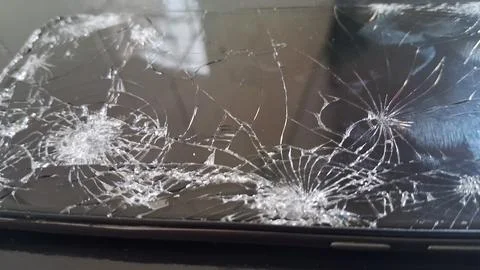 Close up view of a smartphone screen with shattered glass cracks Stock Photos