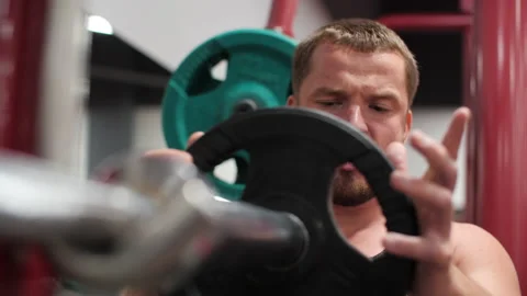 Close-up view of smiling handsome man holding barbell in gym Stock Footage 136715992