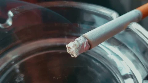 Close up view of Smoldering Cigarette in Ashtray Stock Footage 117843192