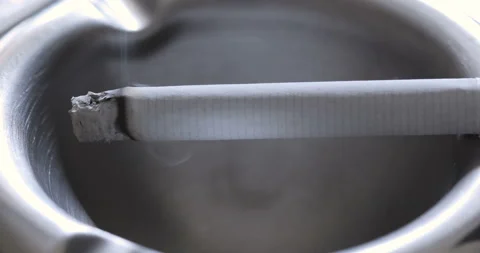 Close up view of Smoldering Cigarette in Ashtray Stock Footage 128896156