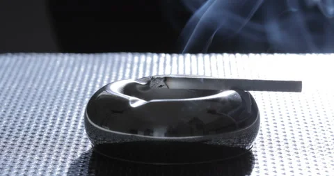 Close up view of Smoldering Cigarette in Ashtray Stock Footage 129549259