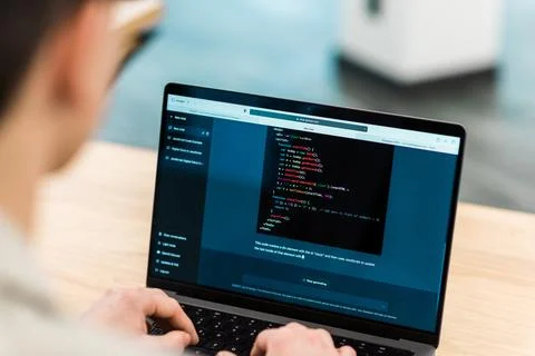 Close view of a software developer generating code in an AI chat by giving a  Stock Photos