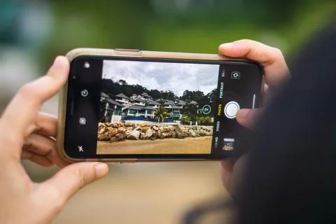 A close up view of someone taking beach resort picture using smartphone Stock Photos