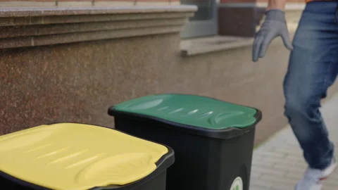 Close view of the sorting bin and the male hands in gloves puts two glass Stock Footage 205271253