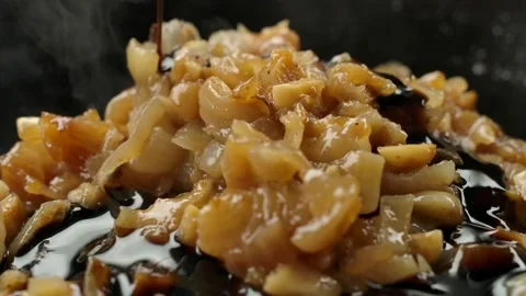 Close-up view of soy sauce poured on onion roasting and caramelizing on the pan Stock Footage 233617097