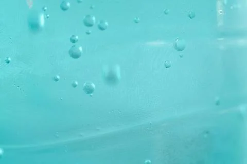 Close-up view of sparkling water with tiny air bubbles suspended in turquoi.. Stock Photos