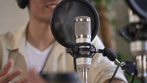 Close view of speaker or presenter speaking and recording podcast, sitting at Stock Footage 171081098