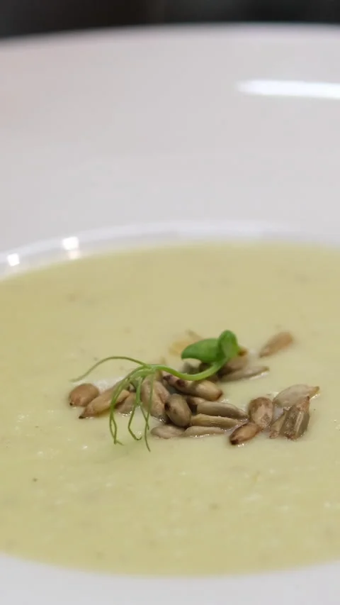 Close up view Spoon scoops up broccoli soup with sesame seeds on the surface Stock Footage 281064246