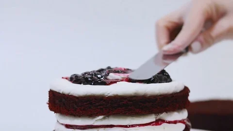 Close up view of spreading red jam on the multilayered cake, Stock-Footage 106614572