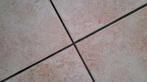 Close up view of square beige ceramic floor tiles intersecting Stock Photos