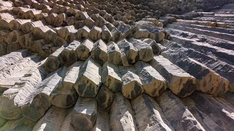Close-up view of stacked concrete segments showing erosion and layered shadows Stock Photos