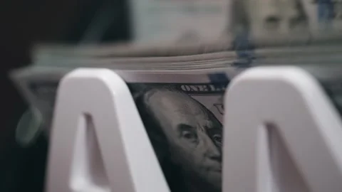 Close-up view of stacked U.S. dollar bills in a white money holder, showcasing Stock Footage 331080395
