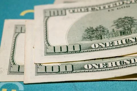 Close-up view of stacked US one hundred dollar bills on a blue surface Stock Photos