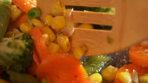 Close up view of steaming vegetables being tossed mixed up in the pan while Video stock 107382250