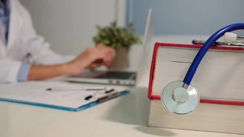 Close up view of stethoscope with books on table and female doctor 스톡 동영상 251941629