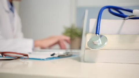 Close up view of stethoscope with books on table and female doctor Vídeos de archivo 251941670