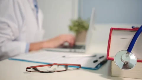 Close up view of stethoscope with books on table and female doctor 스톡 동영상 251941681