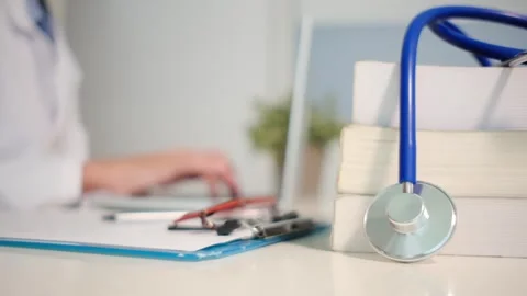 Close up view of stethoscope with books on table and female doctor Stock-Footage 251941693